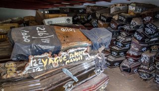 Los féretros, apilados; deben ser ubicados en una fosa común